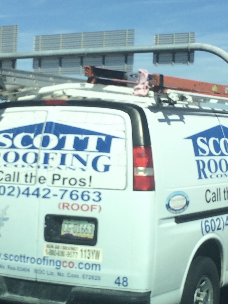 Pink Ladder Rag tied to a Scott Roofing Company Ladder, Certainly could use a Ladder Flag Device because the van says Pros.